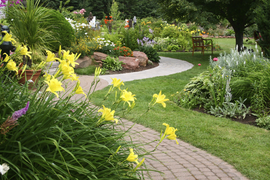 manicured garden with flowers, pathway and bench frontier landscaping