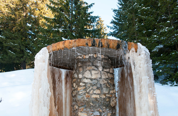 Image of an outdoor water feature with frozen water. Read our blog to learn steps to winterize your outdoor water feature.
